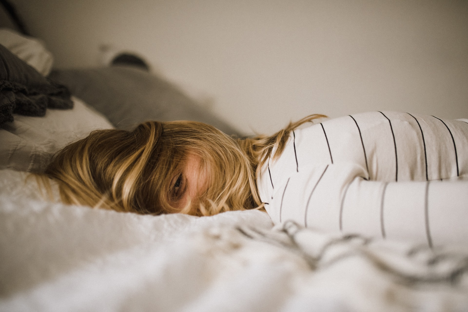 A tired person lying on a bed.